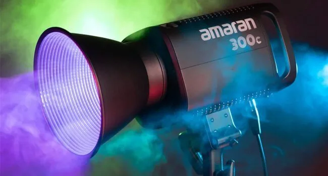 Iluminador Amaran emitindo luz roxa em ambiente de estúdio